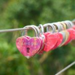 red and gold padlock on gray metal wire